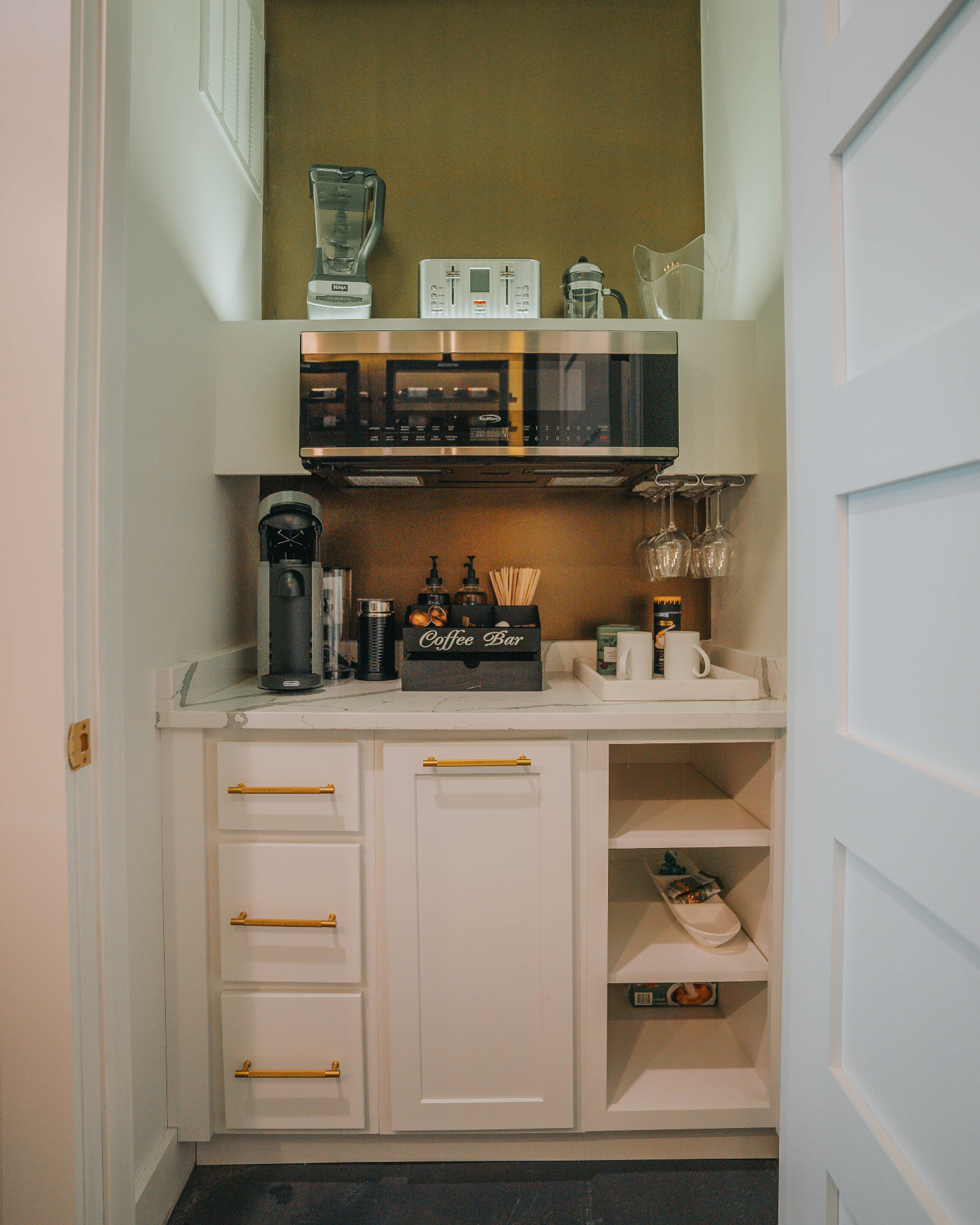 Butler's pantry coffee bar with marble counter and brass hardware