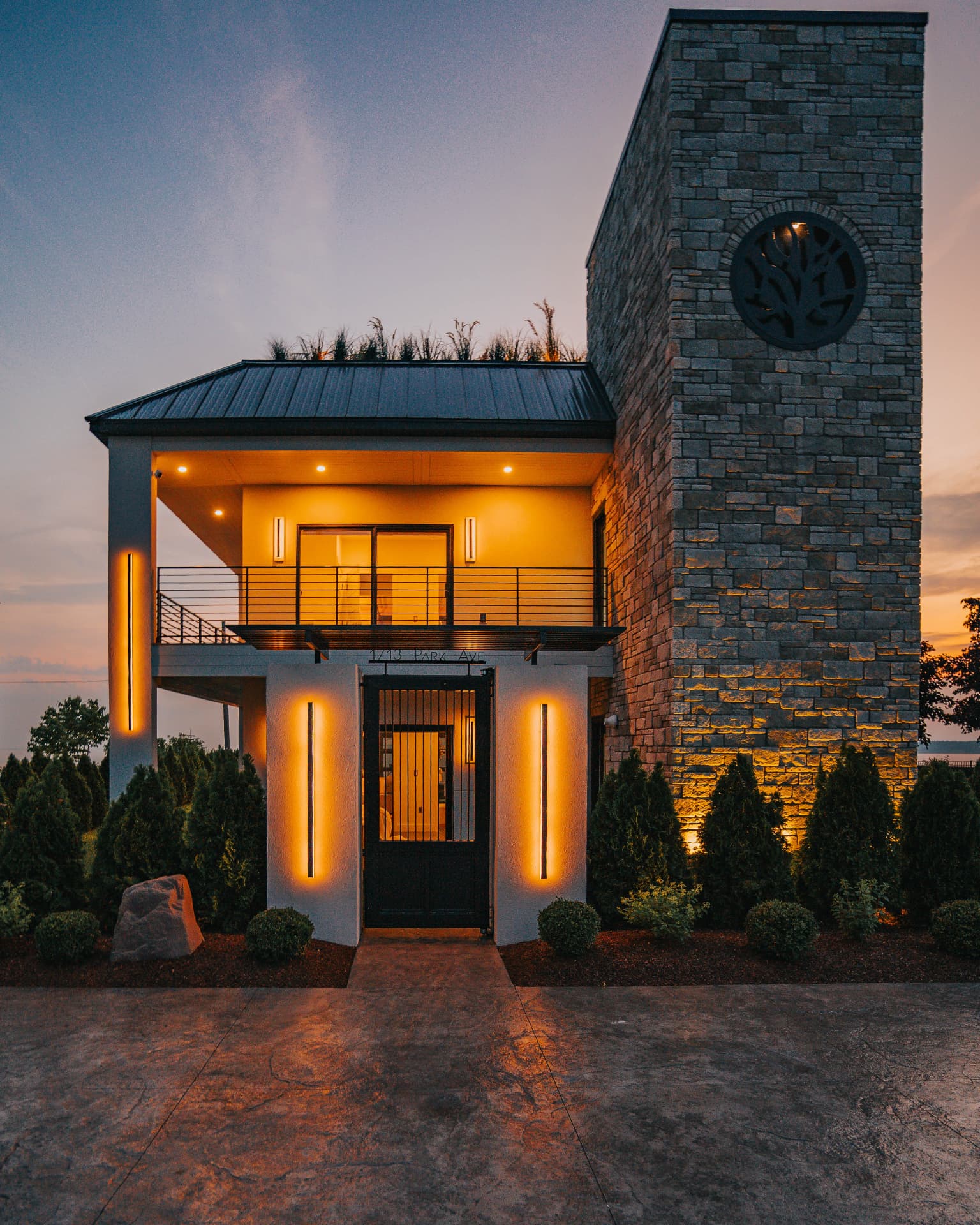 Illuminated stone-and-stucco entry facade of 1713 Park Avenue at dusk