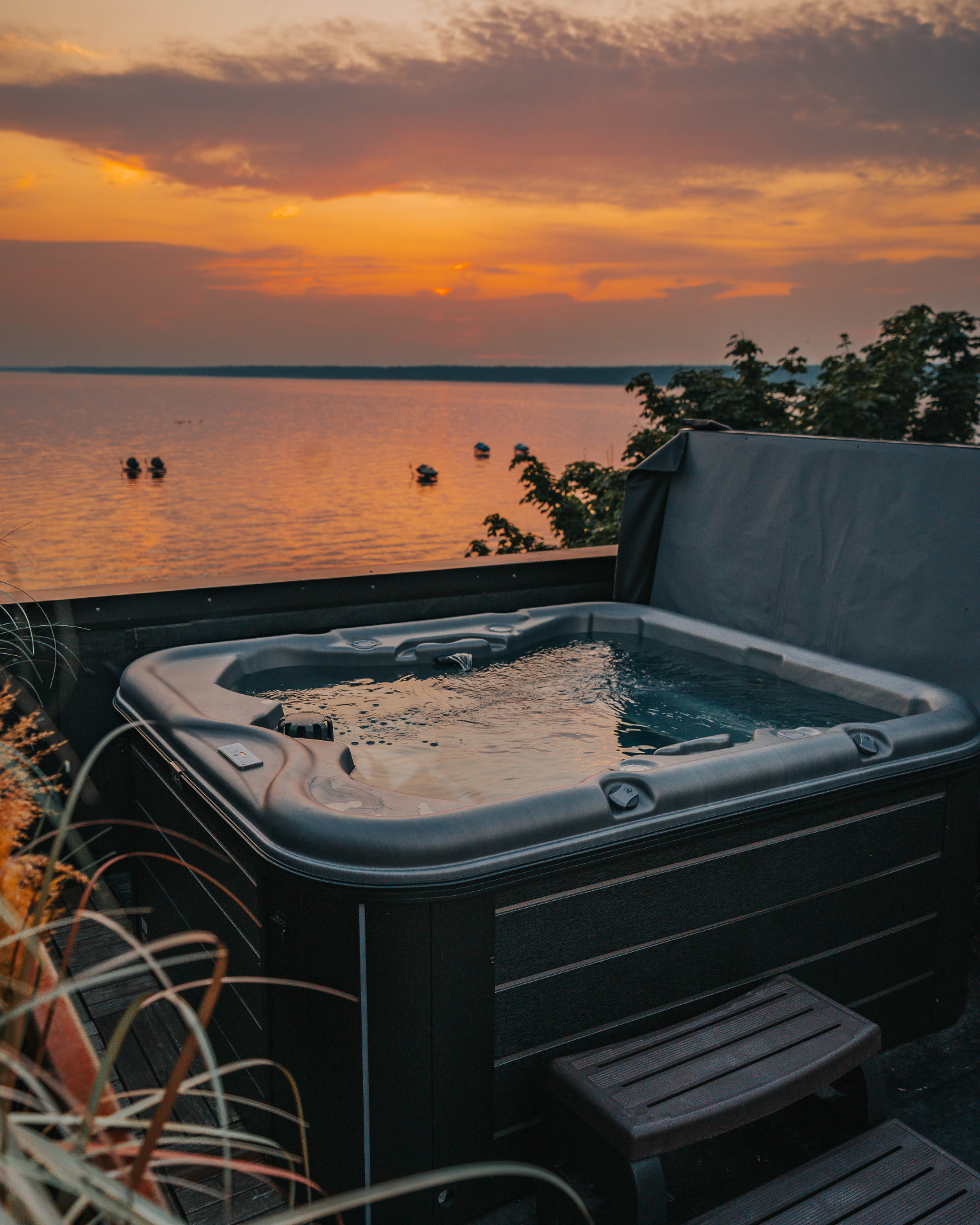 Rooftop hot tub set against an orange sunset over the lake