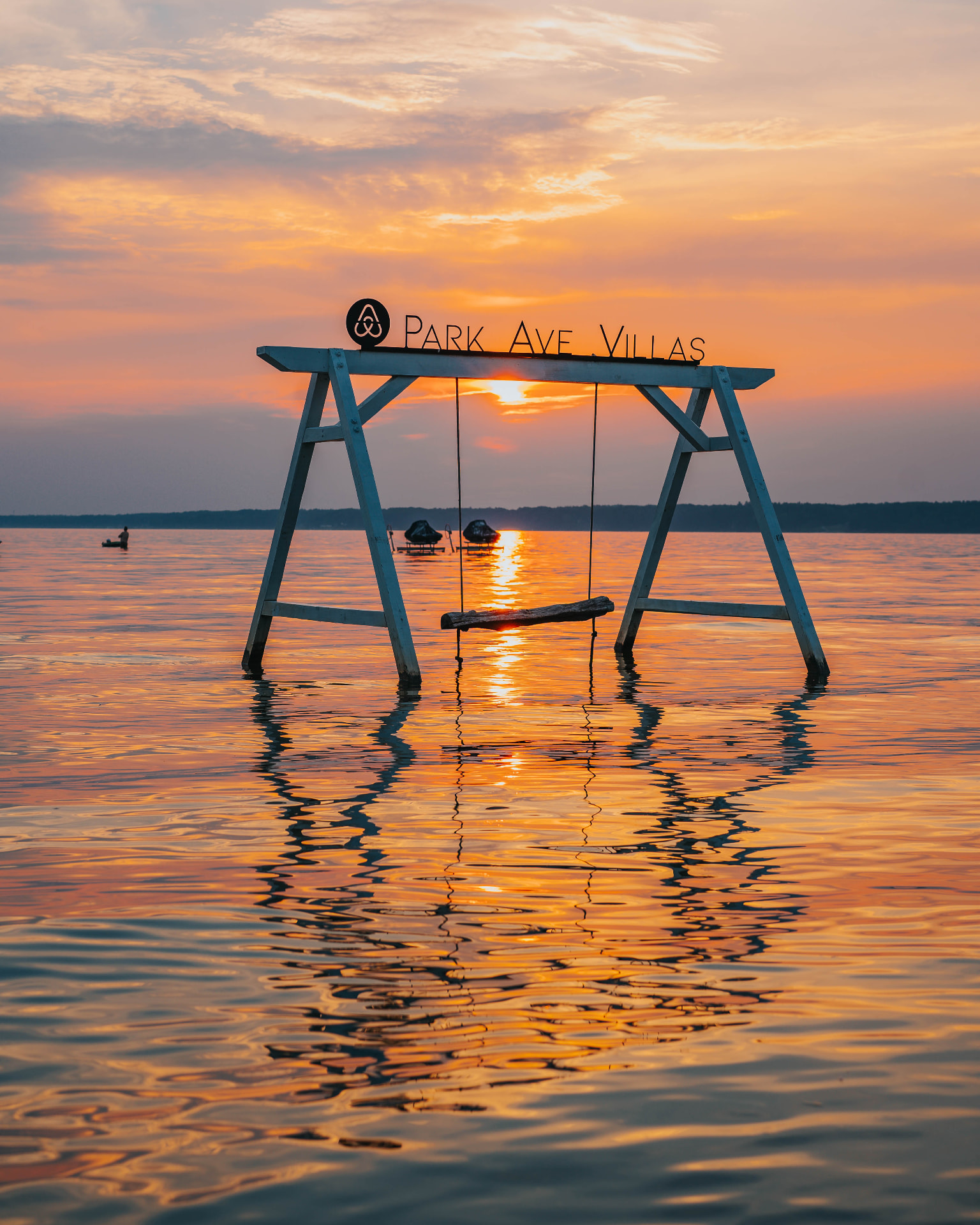 Park Ave Villas swing standing in the shallows of Oneida Lake at sunset