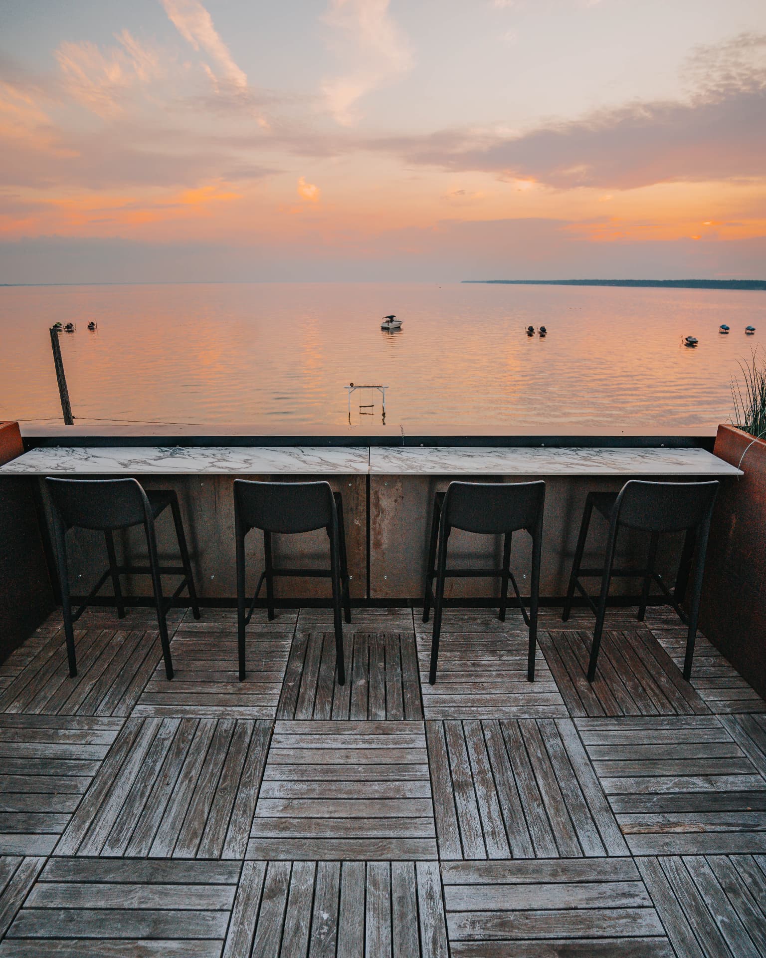 Marble rooftop bar with four stools facing the western sunset over Oneida Lake