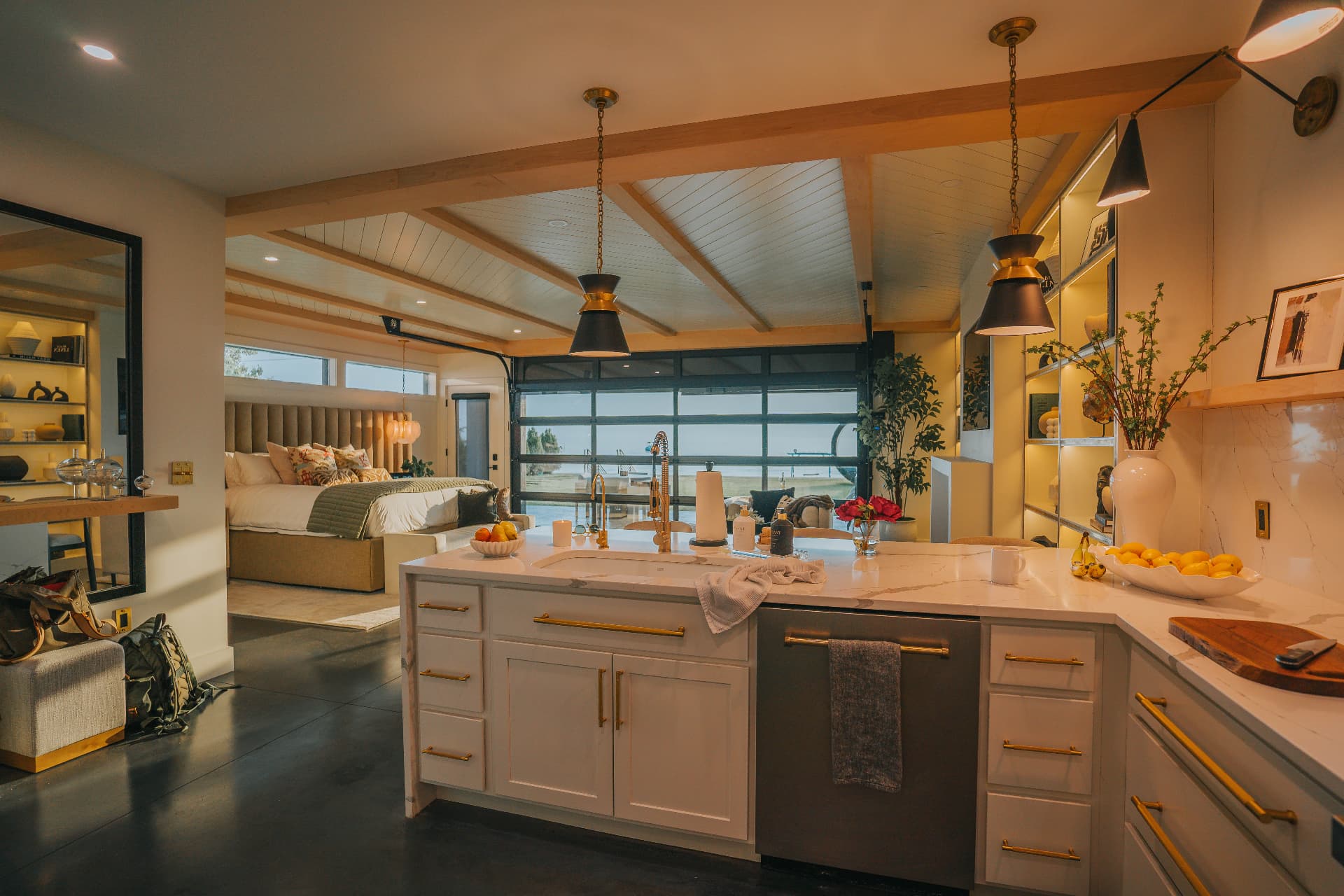 Marble kitchen island with brass fixtures beside the villa's open living and sleeping quarters