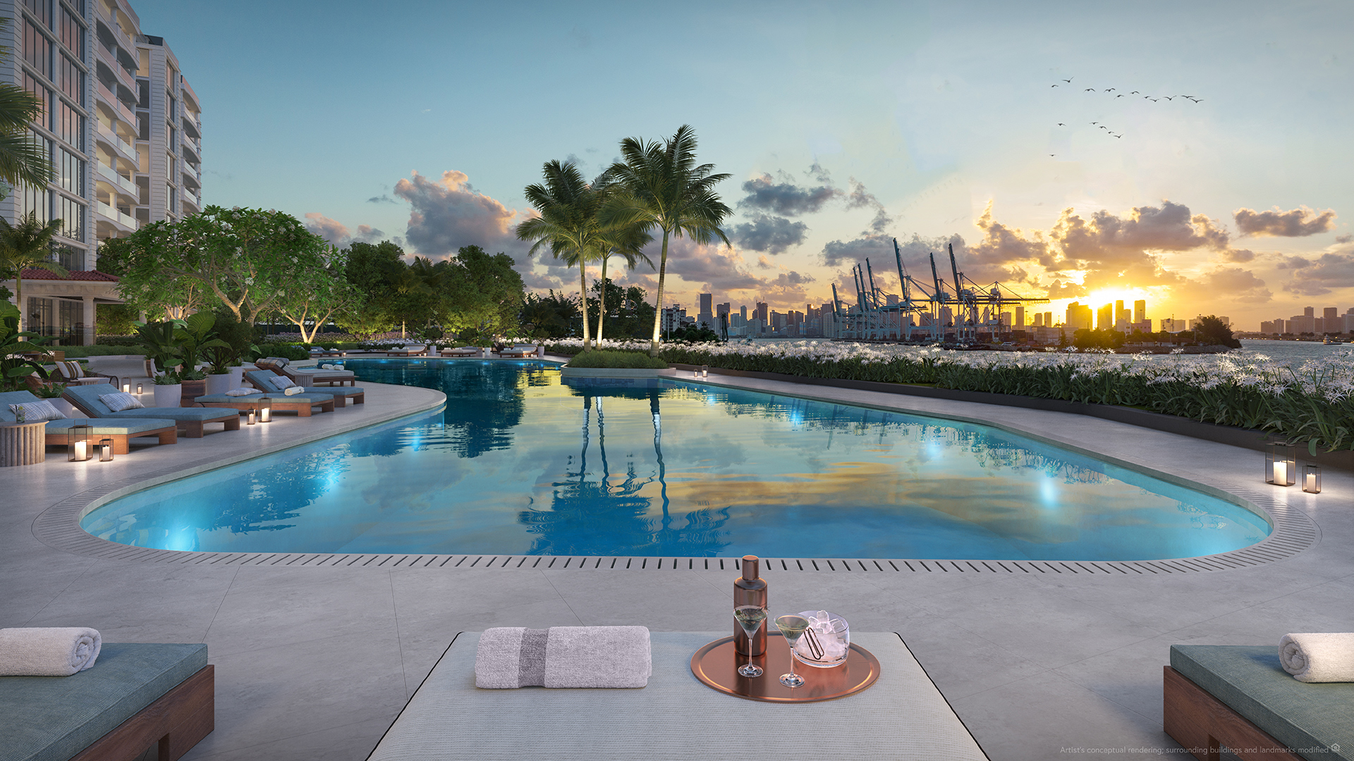 The Residences at Six Fisher Island — waterfront pool deck at sunset with Miami skyline views